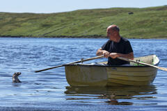 Billy e Molly si siedono sulla barca a remi di Billy nel mare appena al largo delle Shetland occidentali.