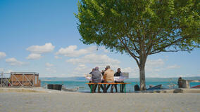 Un gruppo di pescatori gusta la zuppa sbroscia all'aperto, con lo sfondo scenografico del Lago di Bolsena. Tucci in Italy - Lazio