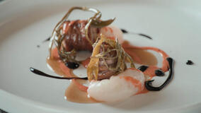 Torcinello, un insaccato tradizionale, servito con scampi, asparagi di mare e salsa di peperoni dolci. Tucci in Italy - Abruzzo