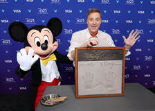 Topolino con Alan Tudyk mentre gli vengono prese le impronte delle mani al Disney Entertainment Showcase del D23: Legends il 16 agosto 2026 ad Anaheim, California