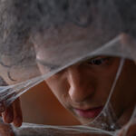 Peter Parker (Tom Holland) peers through the web in Spider-Man: Brand New Day